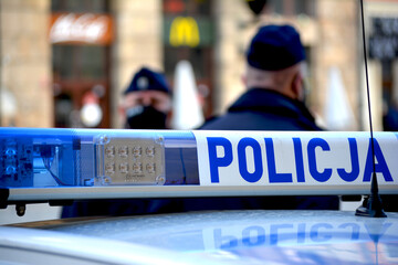 Radiowóz polskiej policji na sygnałach alarmowo przez miasto. 