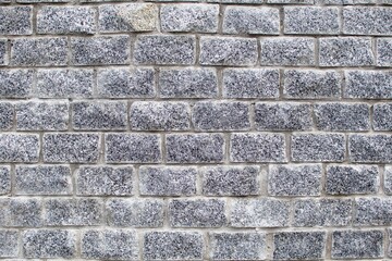 wall texture of gray granite bricks with smooth concrete mortar joints