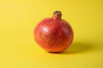 Pomegranate fruit on a yellow background.