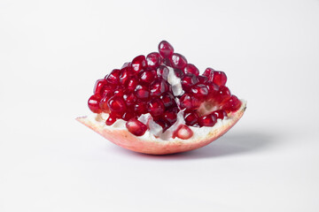 Broken ripe pomegranate fruit on a white background. juicy pomegranate berries. background.