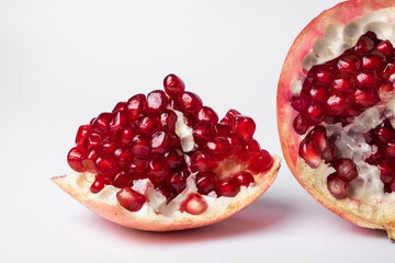 Broken ripe pomegranate fruit on a white background. juicy pomegranate berries. background.