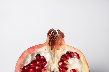 Broken ripe pomegranate fruit on a white background. juicy pomegranate berries. background.