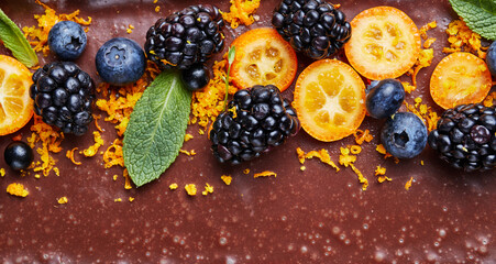 chocolate with whole blackberries, orange slices and zest close-up