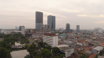 Fototapeta premium Aerial cityscape modern city Surabaya with skyscrapers, buildings and houses. sunset in city skyline with skyscrapers and business centers Surabaya capital city east java, indonesia