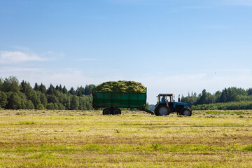 Tractor with a trailer in the field for agricultural work.