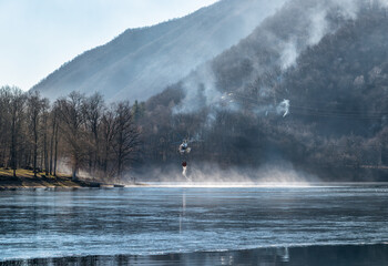 Fire of the Mondonico Mountain above Lake Ghirla with a helicopter that loading water for extinguishing, Valganna, Lombardy, Italy. © EleSi