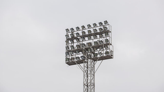 Spotlights On A Soccer Field Against A White Sky