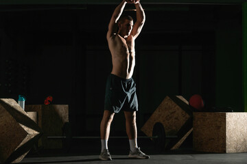 High contrast photo of a healthy fitness guy doing workout using a kettlebell