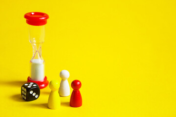 Layout of board games on a yellow background: dice, chips, hourglass timer. Entertainment at home...