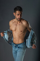 Fototapeta na wymiar Handsome muscular shirtless young man standing confident, profile view, looking at camera