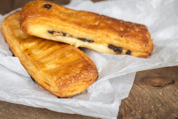 French pastries, tasty chocolate puff bakery on white paper, selective focus