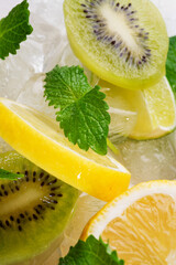 ingredients for fresh lemonade: fresh lemon, lime, melissa, kiwi with ice . flat lay. close up