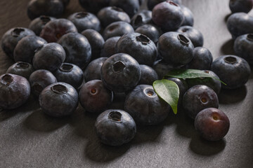 Fresh blueberries are scattered on a dark stone background. Products for a healthy diet. A source of vitamins. 