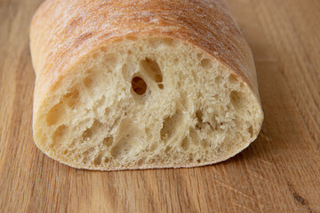 fresh bread slice on wooden rustic table, italian ciabatta bread close up