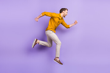 Fototapeta na wymiar Full length profile side photo of young man happy positive smile jump go walk run hurry isolated over purple color background