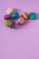 Obraz na płótnie Canvas Vertical shot of colorful macaroons on a pink background.