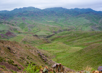 Fototapeta na wymiar Shengeldi mountains covered with fresh vegetation on an overcast spring day