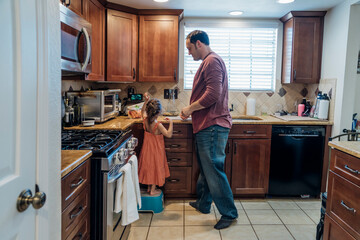 Dad helping daughter in kitchen