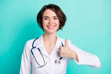 Photo of young woman happy positive smile nurse clinic show thumb-up fine cool ad advice isolated...