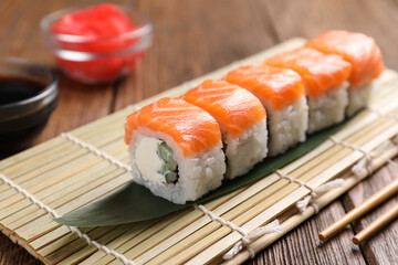 Tasty sushi rolls served on wooden table, closeup