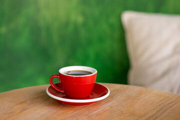 coffee in a red cup on a wooden table, start the day or lunch with partners in a coffee shop, meet with friends or coffee alone, enjoy the taste of black coffee Americano or cappuccino