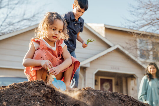 Happy Girl Digging In Pile Of Dirt