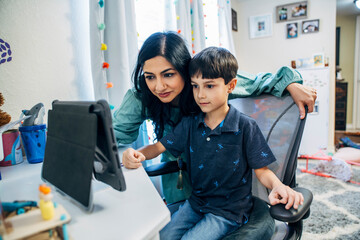 Mom helping son look at something on iPad tablet computer