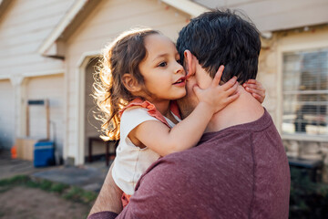 Obraz premium Girl in whispering secret in dad's ear