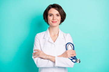Photo of young woman happy positive smile crossed hands hold stethoscope doctor isolated over teal...
