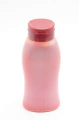 White bottle with red food product on white background