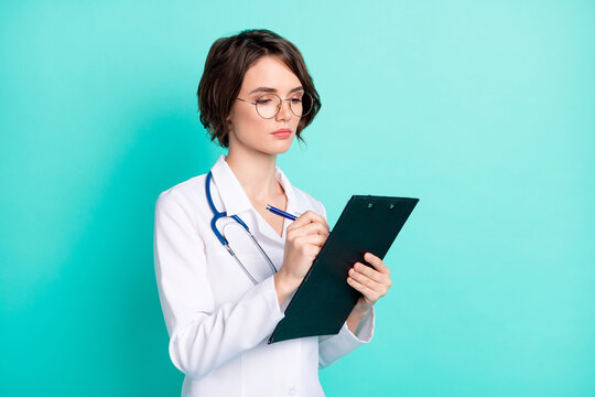 Photo portrait of nurse writing diagnosis on consultation isolated vibrant teal color background