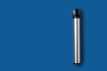 Disposable e-cigarette in metallic color on blue isolated background. The concept of modern smoking, vaping and nicotine. Top view