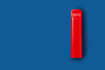 Disposable e-cigarette in red color on blue isolated background. The concept of modern smoking, vaping and nicotine. Top view