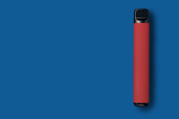 Disposable e-cigarette in dark red color on blue isolated background. The concept of modern smoking, vaping and nicotine. Top view