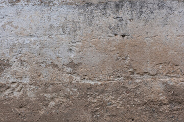 Old, cracked foundation cement, with holes, scratches, sand and white paint residue.