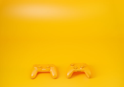 Two gamepads on a yellow table 