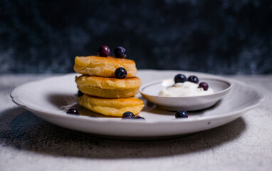 small pancakes made of cheese and flour on a white beautiful plate with a blue background delicious food