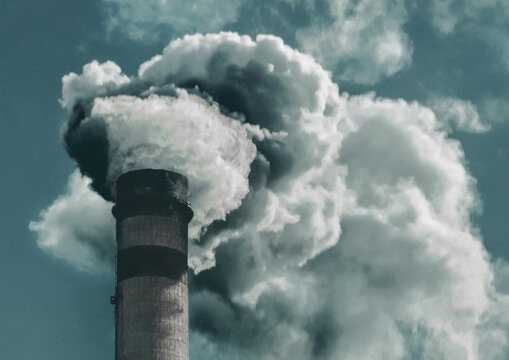 Environmental pollution, environmental problem, smoke from the chimney of a plant or thermal power plant against the sky