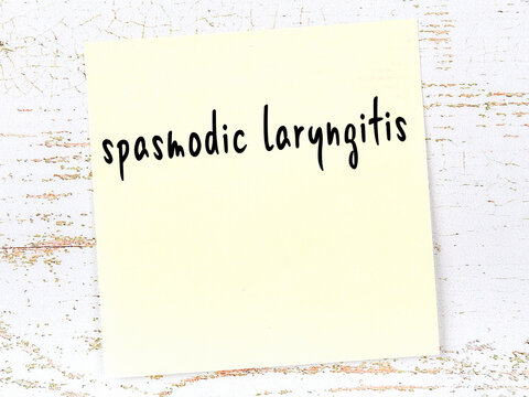 Yellow sheet of paper with word spasmodic laryngitis. Reminder concept