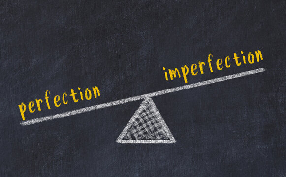 Chalk drawing of scales with words perfection and imperfection. Concept of balance