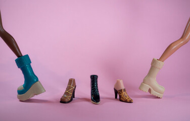 Doll shoes with two dolls walking on soft pink background. Minimal shopping and fashion concept. With copy space.