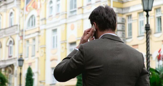 Businessman Portrait From Behind On The Streets Of London.the Manager, Rear View, Walks Down A European Street In Old London, Talking On The Phone. Status Man In An Expensive Brown Suit Talking. 