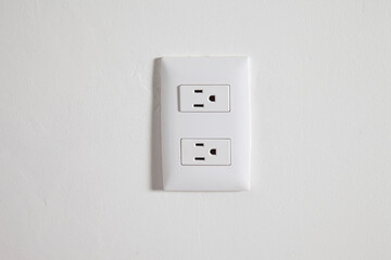 Isolated north american power outlet plug in socket on a white wall background 