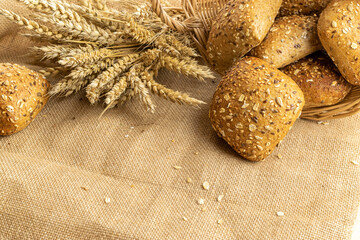 Baguette bread. Rye bakery with crusty loaves and crumbs. Fresh loaf of rustic traditional bread with wheat grain ear or spike plant on natural cotton background. Concept - Cooking at Home.