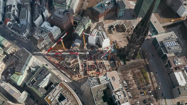 Aerial orbit of cranes and construction equipment by old St. Nikolai Memorial church in Hamburg city center