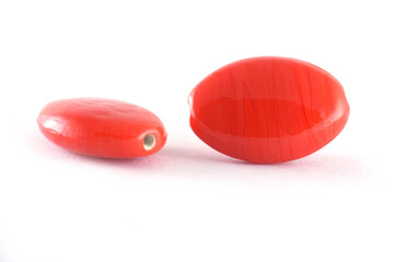 Close up of red Beads on the white background.Oval shape beads, Background or texture of beads. macro,used in finishing fashion clothes. make bead necklace or string of beads for woman of fashion.