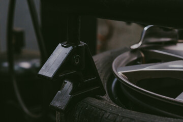 Closeup of a tire in a workshop with a tool taking off the rim