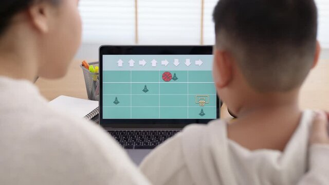 Young asia student remotely learn online at home with parent in coding unplugged coding program on laptop computer for beginner kids. Self study parent coach teach child in basic coding language.