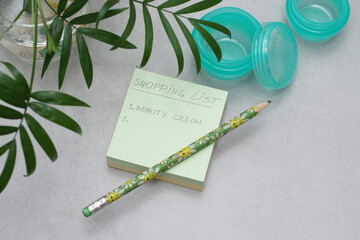 A handwritten shopping list on A Post-it Sticky Notes..Empty unbranded jars for skincare cream..Green plastic containers without labels on gray background..Cosmetic and shopping planning concept. - 429719617