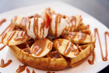  Waffle with banana and dulce de leche on top. This combination of flavors is common in Colombia.    